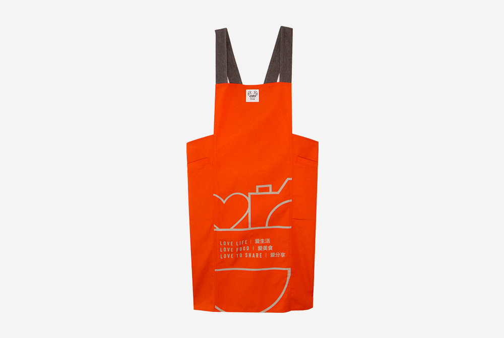 Love, Afare Kitchen Apron in vibrant orange – durable, stylish, and functional apron with side pockets for home cooks and bakers.